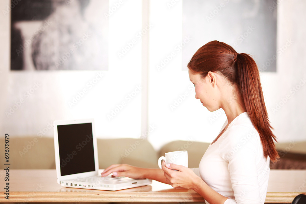 junge Frau am Laptop mit Kaffeetasse junge Frau am Laptop mit Kaffeetasse