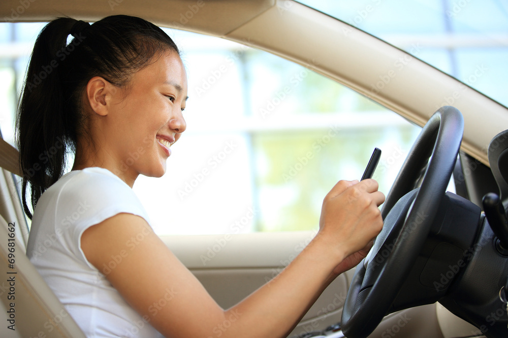 woman driver sit in car use her smart phone