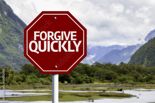 Forgive Quickly red sign with a landscape background photo