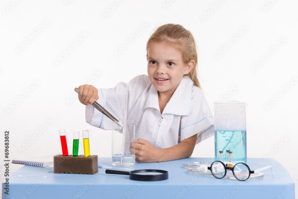 Girl throws a piece of reagent into flask in chemistry class Girl throws a piece of reagent into flask in chemistry class