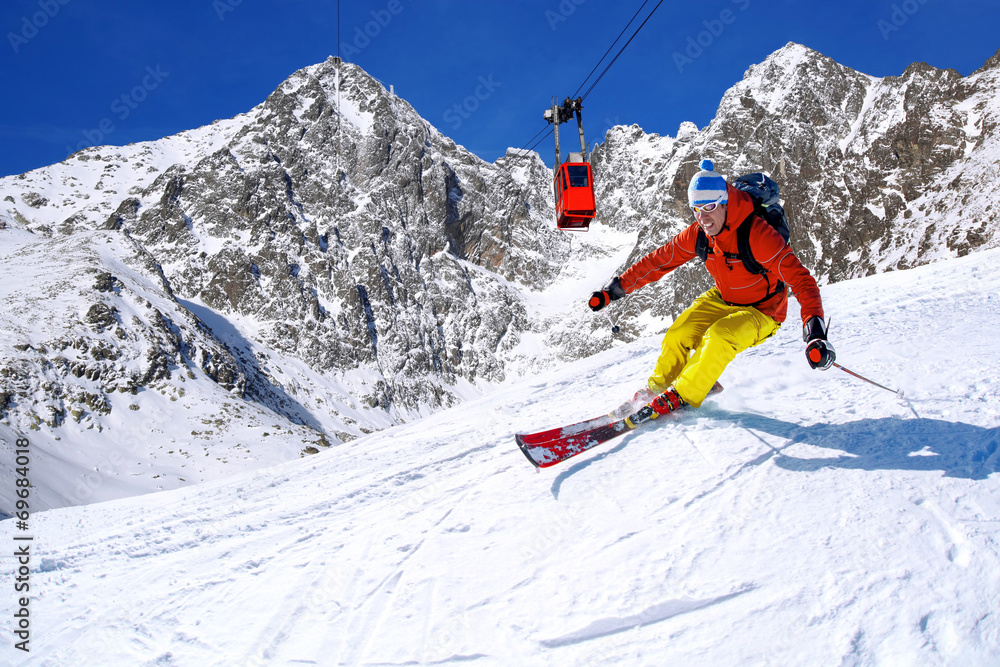 Skier against blue sky in high mountains