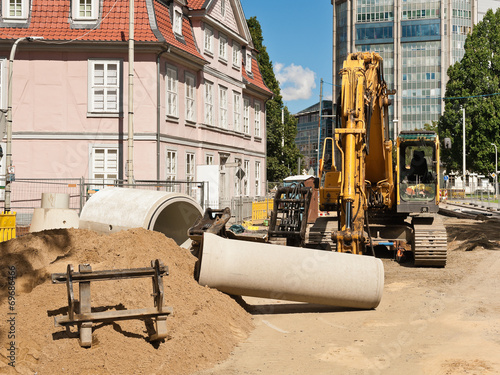 Kanalbau und Strassenbau - Rohre aus Beton und ein Bagger photo