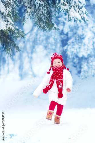Little girl playing in a winter park