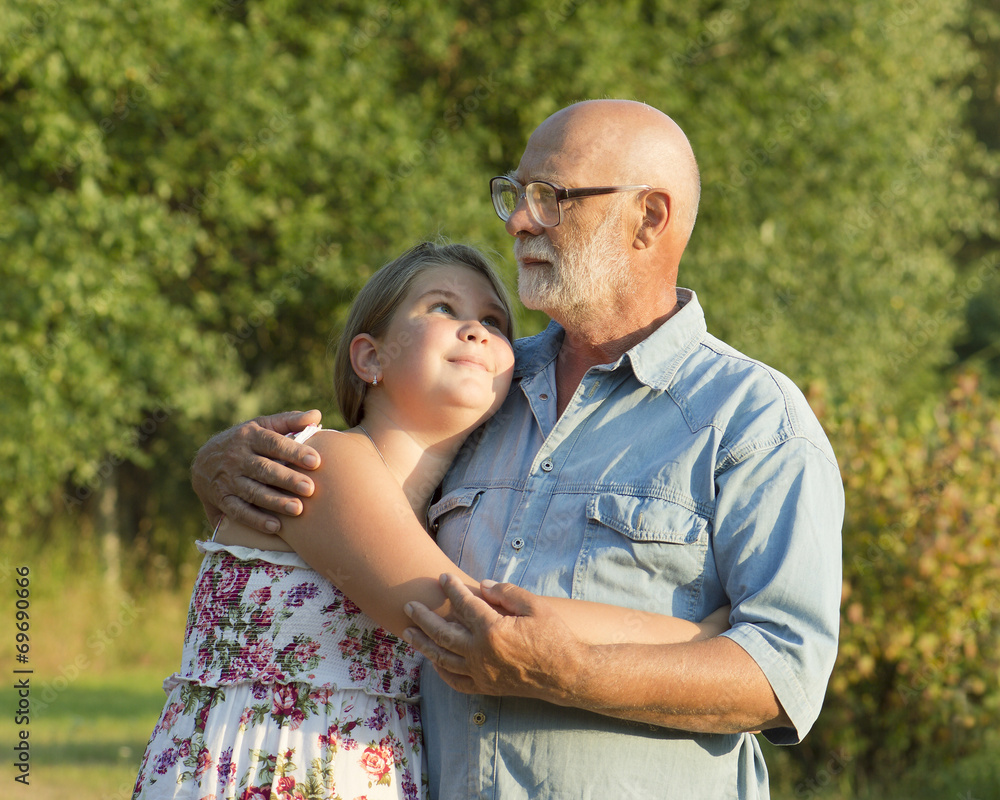 Naklejka premium Outdoor portrait of grandfather with granddaughter.