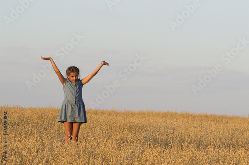 The girl is dancing in oat field.