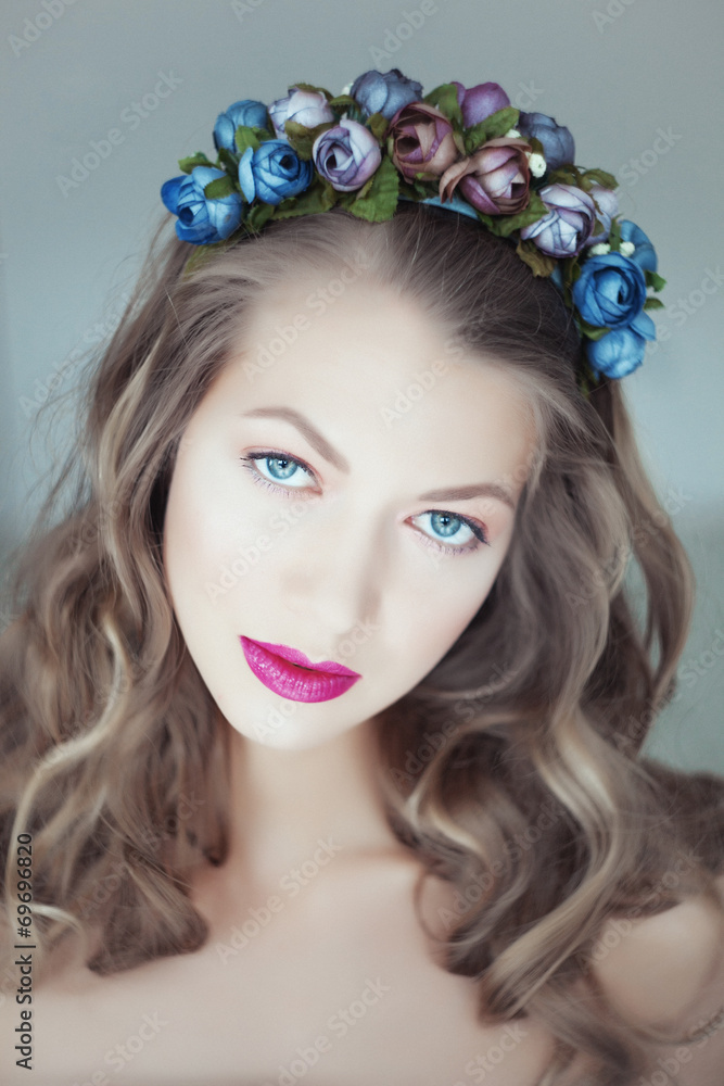 Naklejka premium Portrait of beautiful woman with flowers in hair and blue eyes