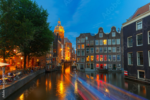 Night city view of Amsterdam canal, church and bridge