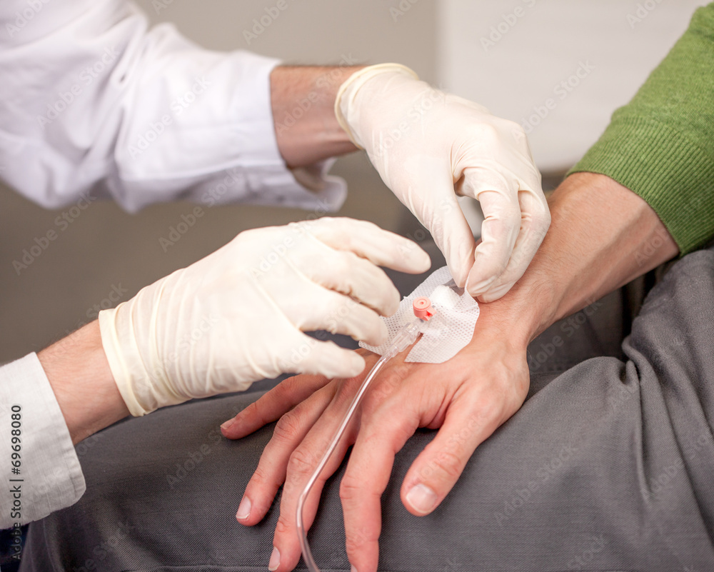 Arzt legt einen Venenkatheter an der Hand Arzt legt einen Venenkatheter an der Hand