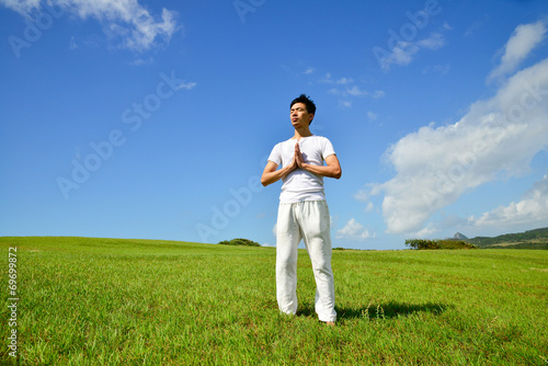 portrait of healthy young man doing yoga against sky
