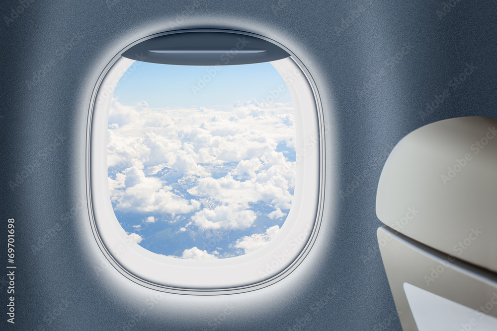 Fototapeta premium Aeroplane or jet window with clouds behind, traveling concept.
