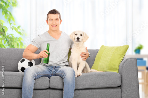Man sitting with dog on couch at home