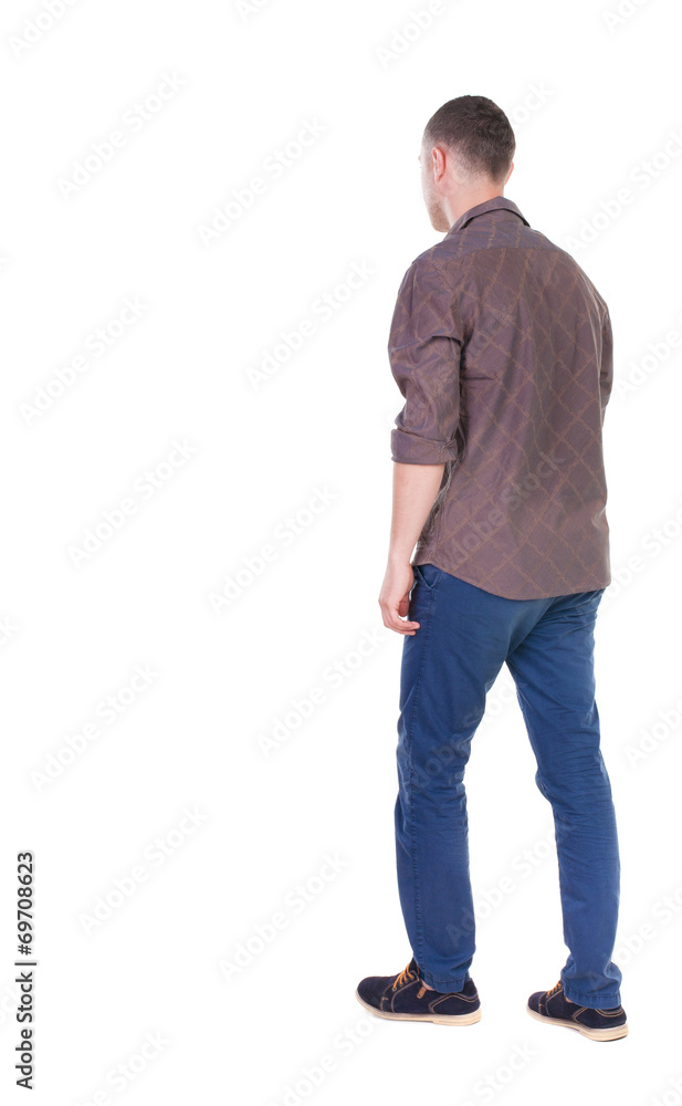 Back view of going handsome man in jeans and a shirt. Back view of going handsome man in jeans and a shirt.