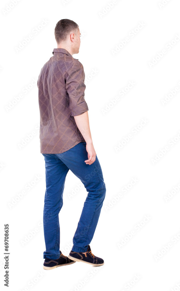 Back view of going handsome man in jeans and a shirt. Back view of going handsome man in jeans and a shirt.
