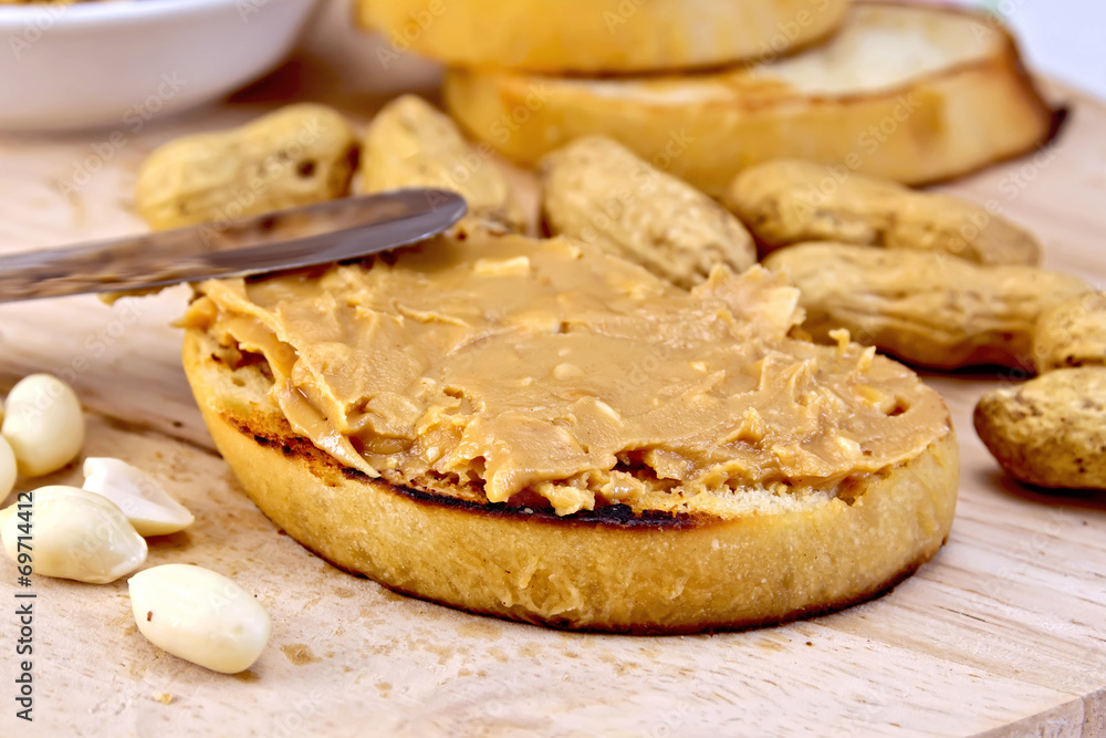 Sandwich with peanut butter and knife on board Sandwich with peanut butter and knife on board