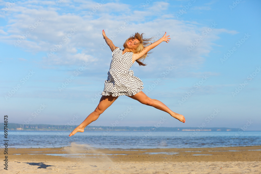 Beautiful young girl jumping on sea Beautiful young girl jumping on sea
