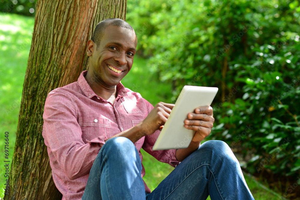 Handsome man with tablet in the park Handsome man with tablet in the park