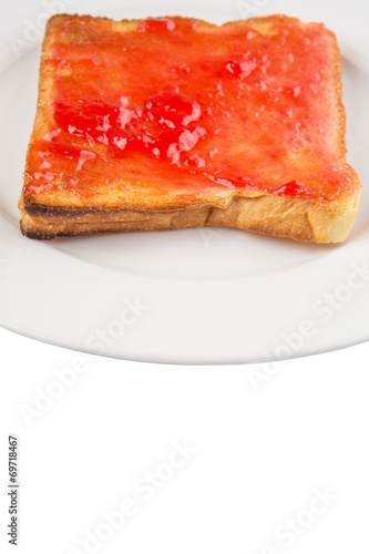 Bread toast with strawberry jam on white plate