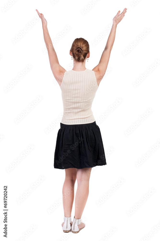 Back view of Beautiful woman in jeans looking at wall and Holds Back view of Beautiful woman in jeans looking at wall and Holds