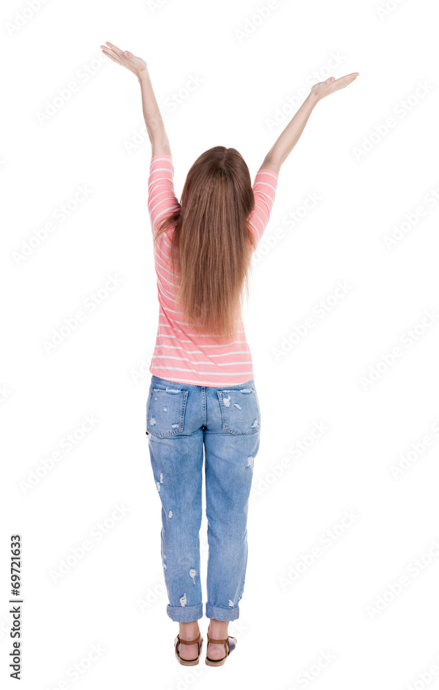 Back view of Beautiful woman in jeans looking at wall and Holds Back view of Beautiful woman in jeans looking at wall and Holds