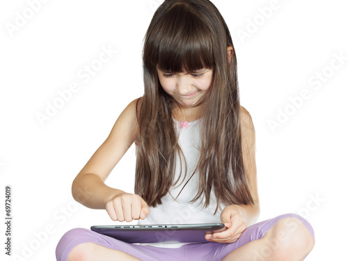 angry child  sitting on the bed with tablet pc isolated photo