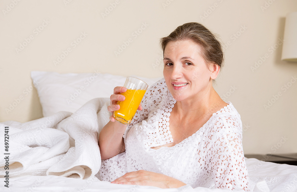 Beautiful woman having breakfast, in bed, bedroom of her house Beautiful woman having breakfast, in bed, bedroom of her house