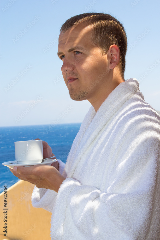 man in bathrobe with cup of coffee