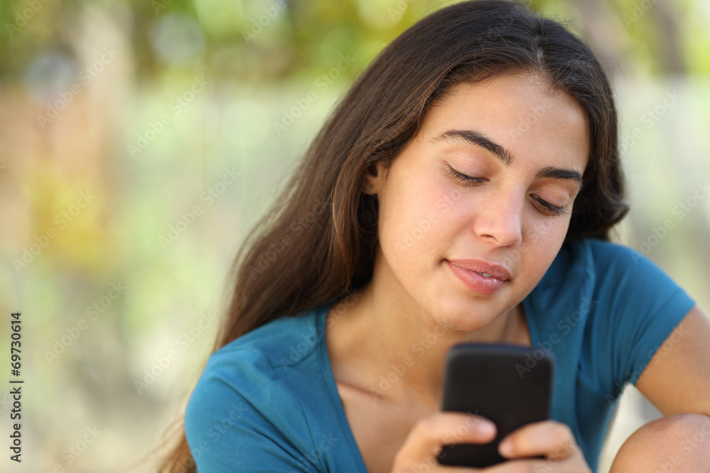 Pretty teenager girl texting in a smart phone Pretty teenager girl texting in a smart phone