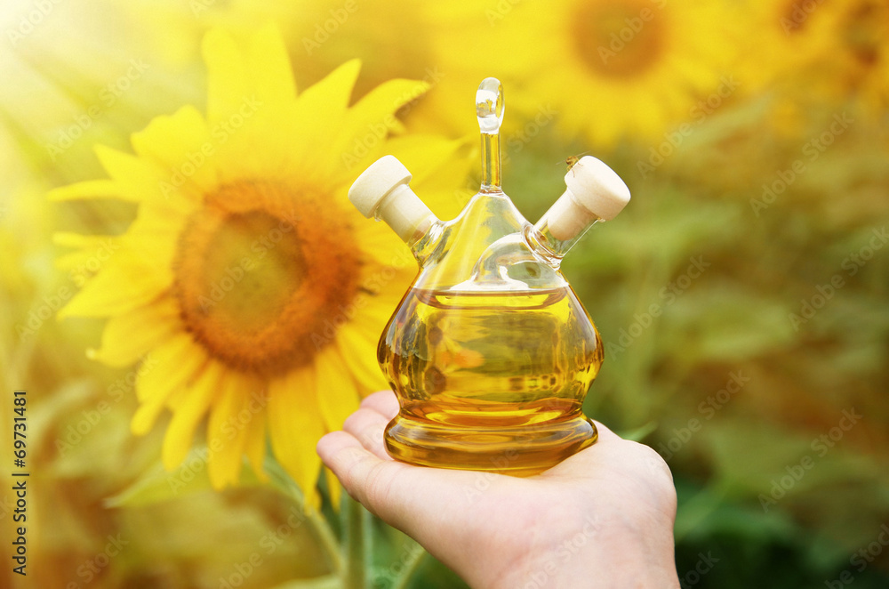 Bottle of oil against sunflowers Bottle of oil against sunflowers