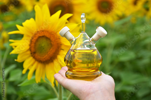 Bottle of oil against sunflowers