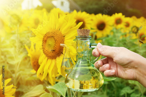 Bottle of oil against sunflowers