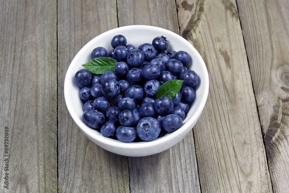 blueberries in porcelain bowl on wooden table blueberries in porcelain bowl on wooden table