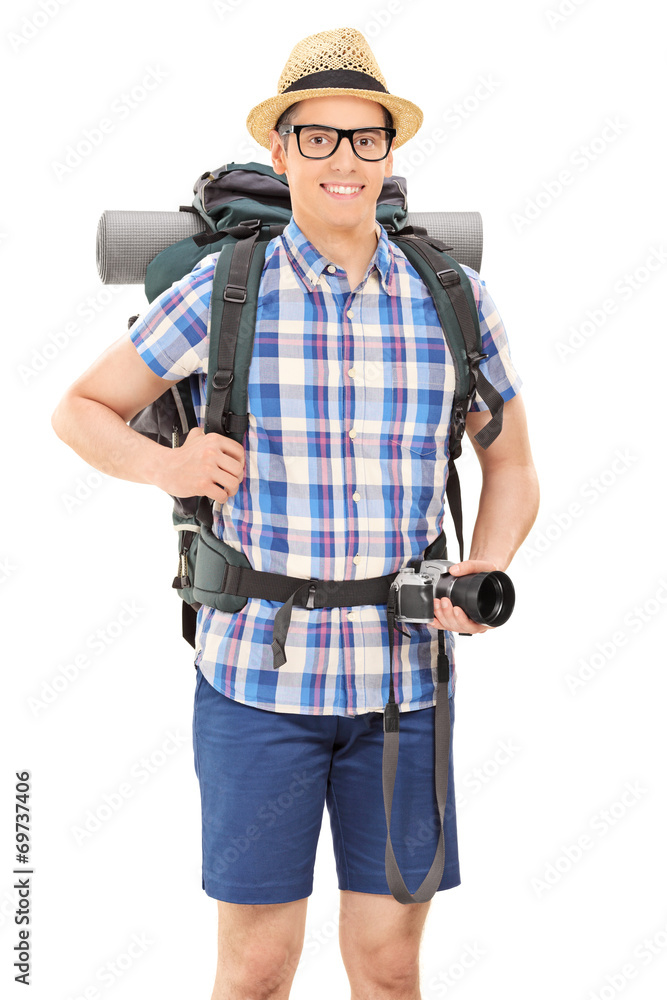 Young male hiker holding a camera and posing Young male hiker holding a camera and posing