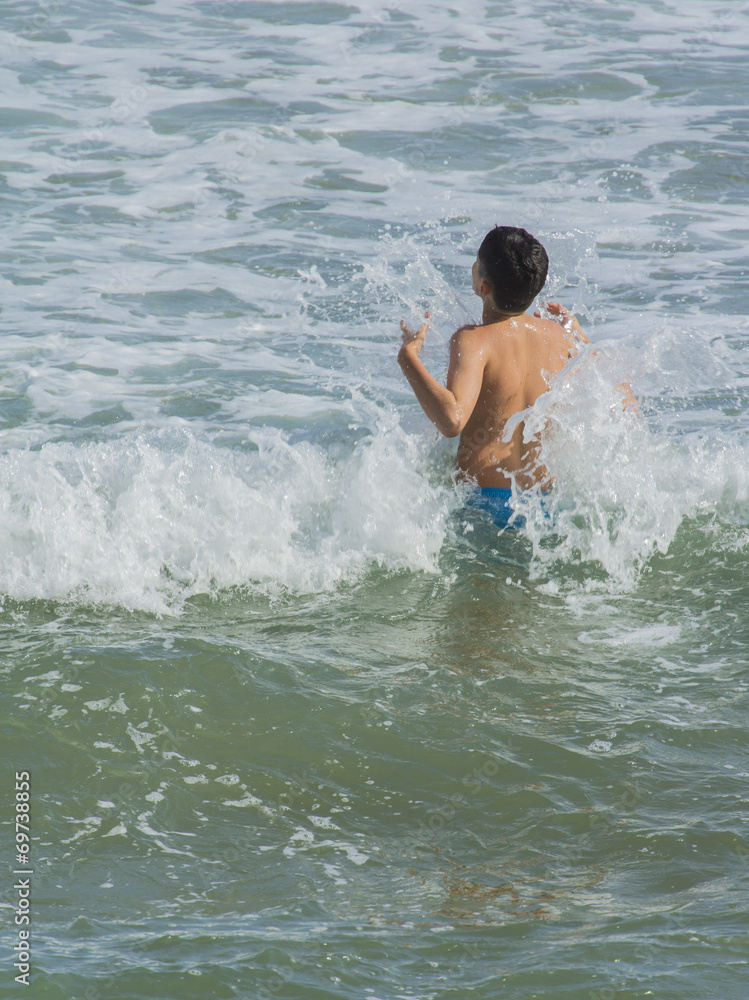 Niño bañandose en el mar