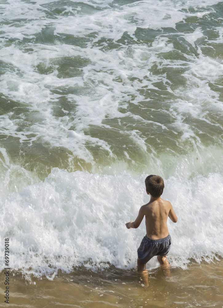 Fototapeta premium Niño jugando en el mar