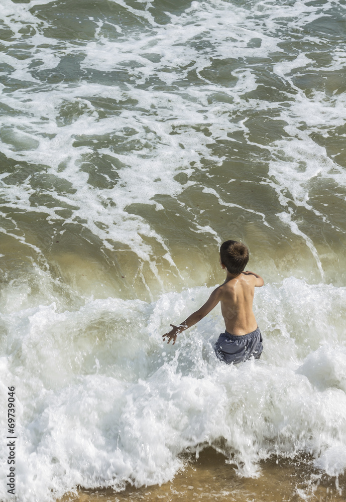 Niño jugando en el mar