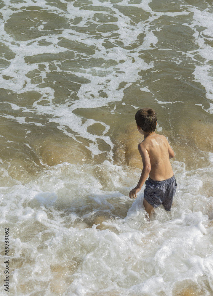 Niño jugando en el mar