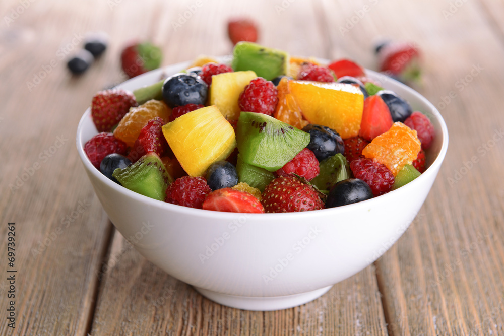 Delicious fruits salad in plate on table close-up Delicious fruits salad in plate on table close-up
