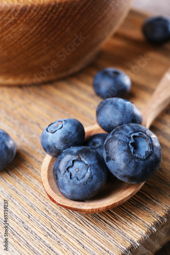 Wooden bowl of blueberries on cutting board on wooden