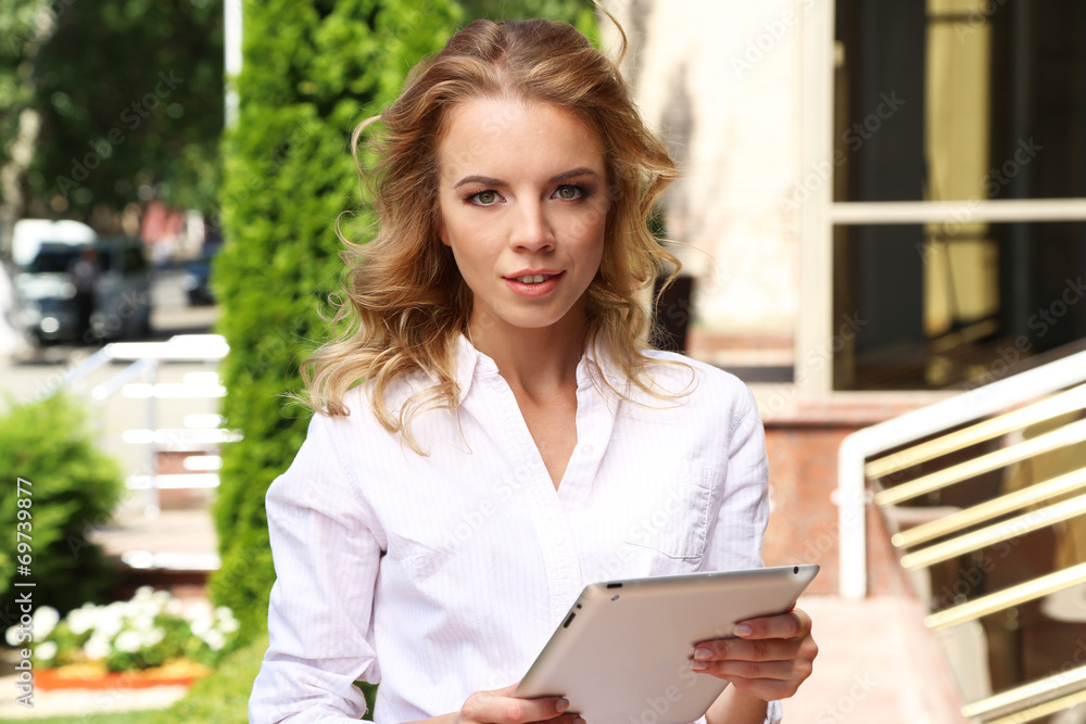 Beautiful young girl with tablet on city street Beautiful young girl with tablet on city street