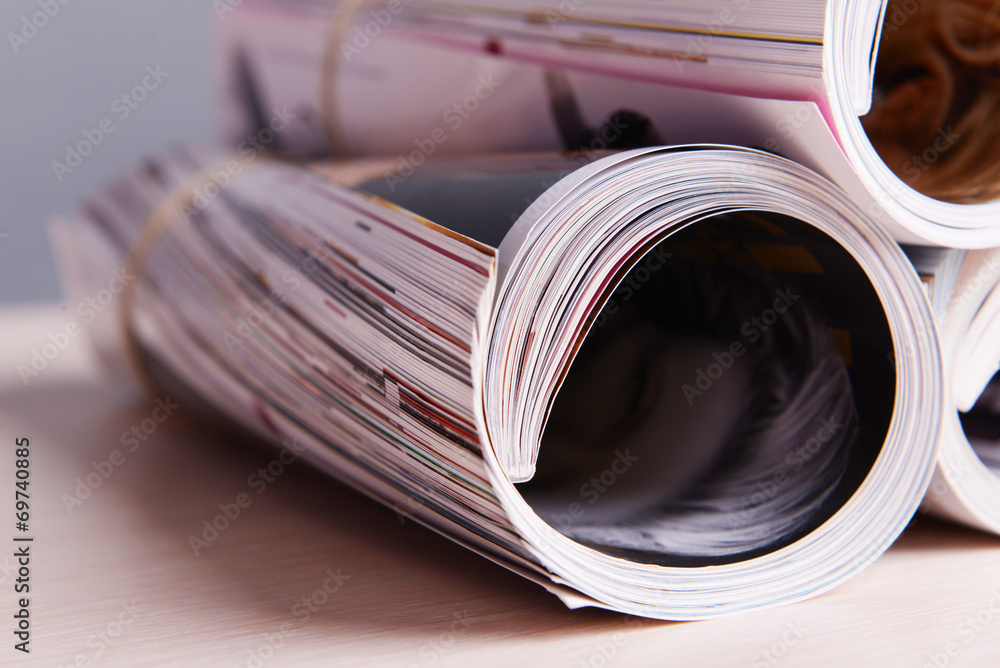 Magazines on wooden table on gray background Magazines on wooden table on gray background
