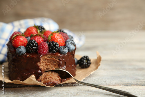 Tasty chocolate cake with different berries on wooden table