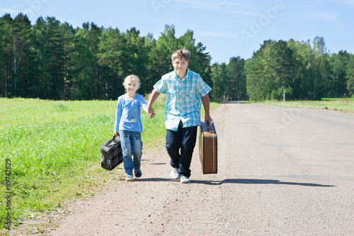cute girl and boy with suitcase