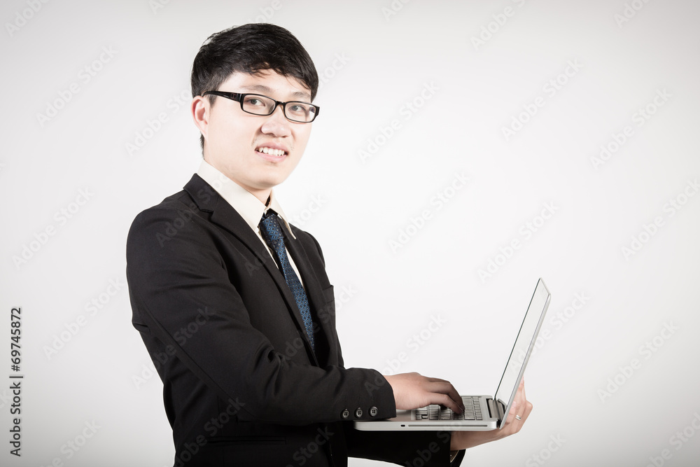 Asian business man using laptop computer isolated on white backg