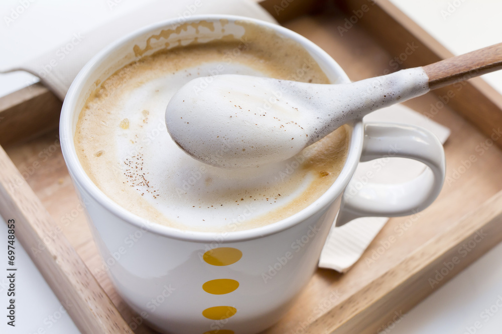 Whipping Cream on a spoon and a cup of coffee Cappuccino Whipping Cream on a spoon and a cup of coffee Cappuccino