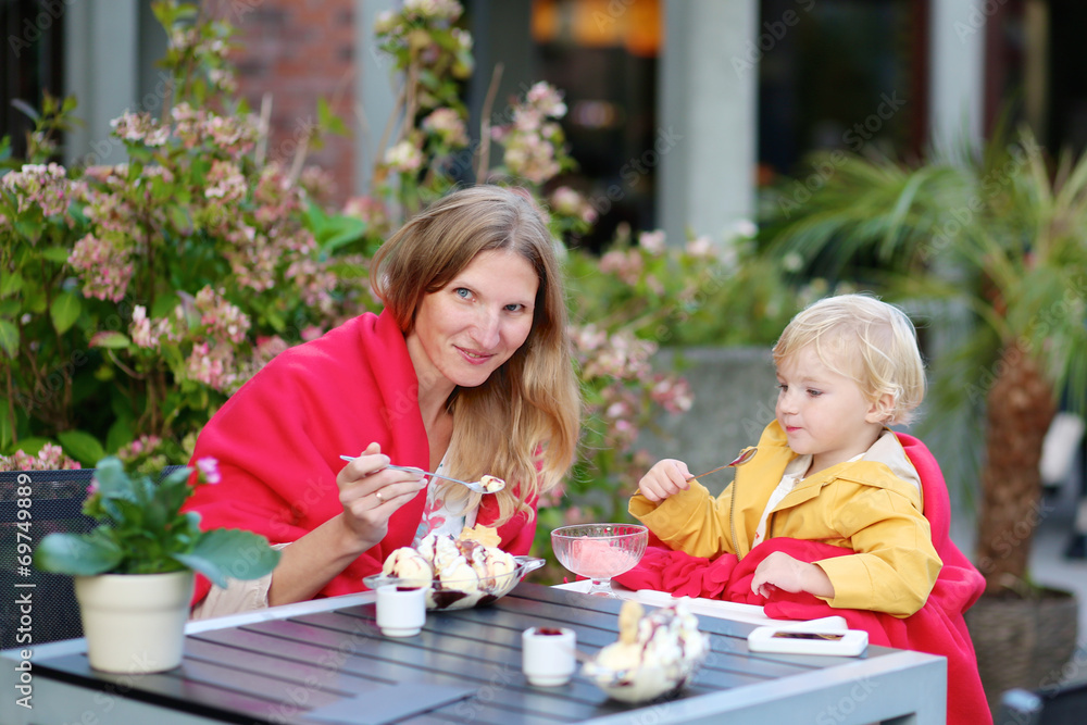 Mother and daughter eating ice cream in cafe Mother and daughter eating ice cream in cafe