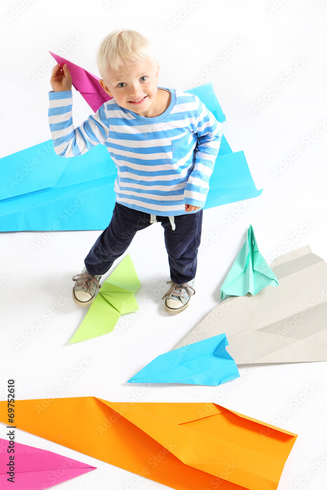 Mały chłopiec  trzyma w dłoni papierowy samolot - obrazy, fototapety, plakaty 