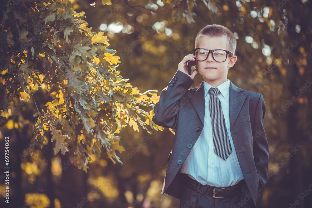 kid businessman with laptop on the park background kid businessman with laptop on the park background