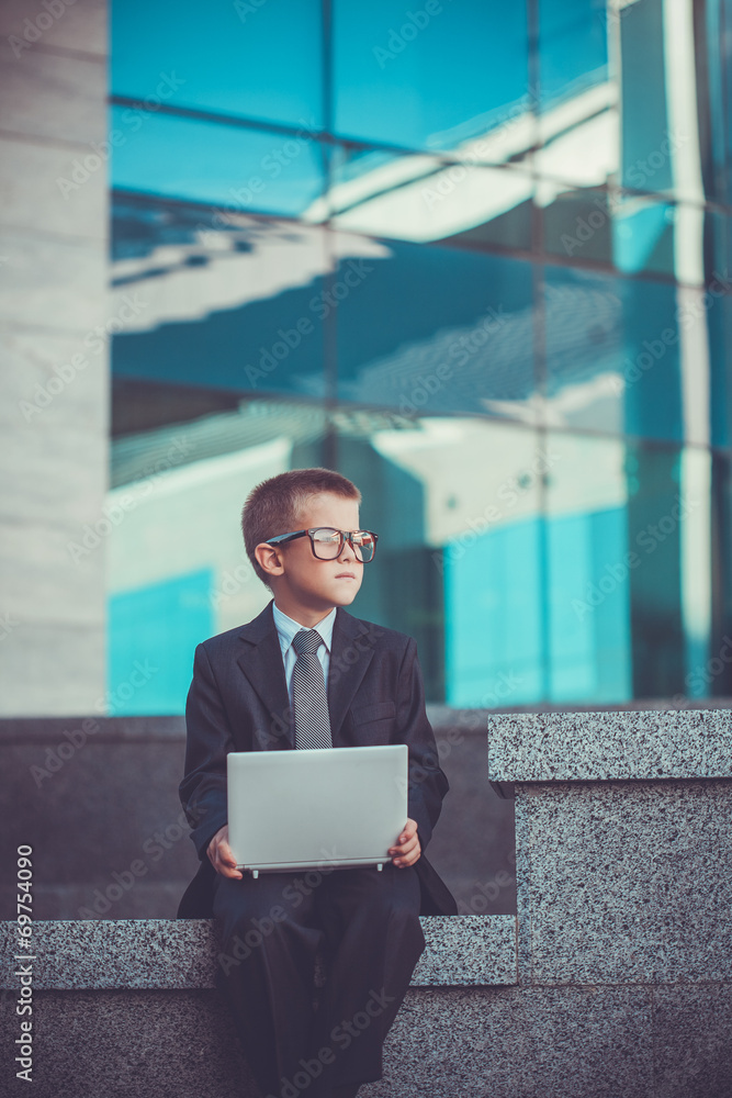 kid businessman with laptop on the blue modern background