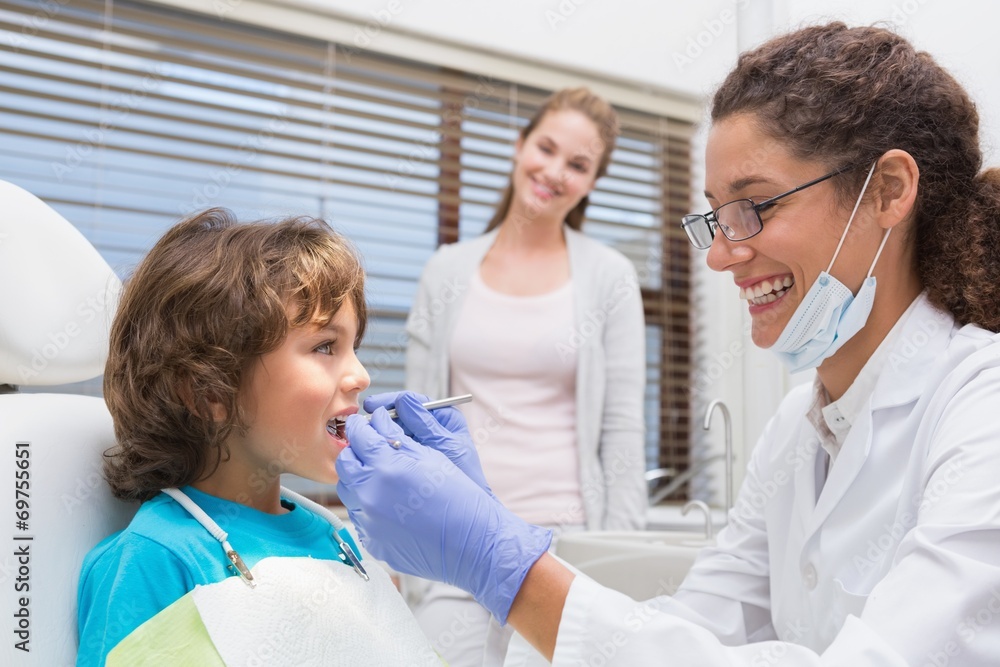 Obraz premium Pediatric dentist examining a little boys teeth
