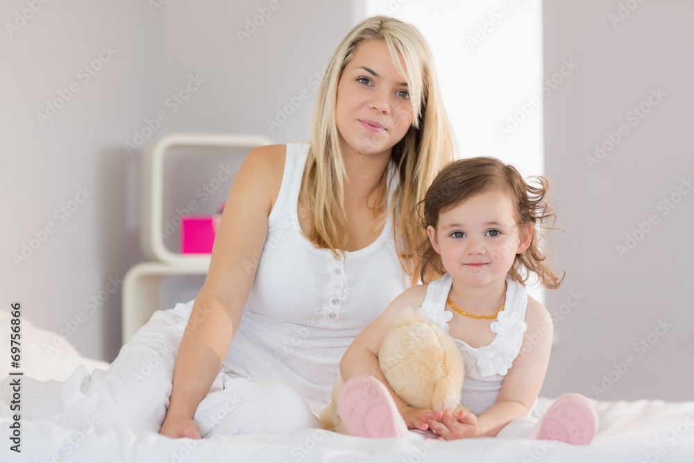 Portrait of mother and daughter sitting on bed Portrait of mother and daughter sitting on bed